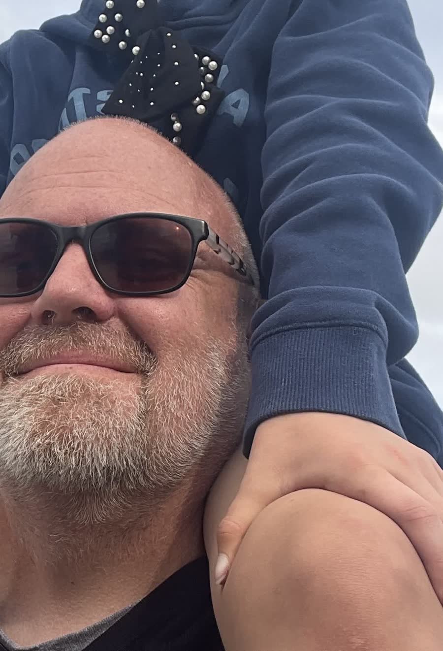 Greg Valiquette outdoors, one of his kids on his shoulders
